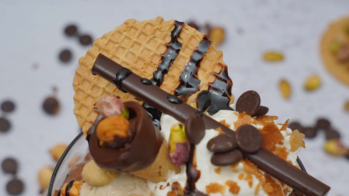 A sundae with gelato, a wafer and chocolate decorations, shot from above
