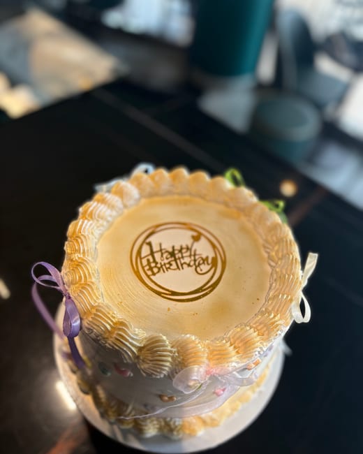 A cake with a caramelised top, piped cream and gold lettering, at the Hannes patisserie