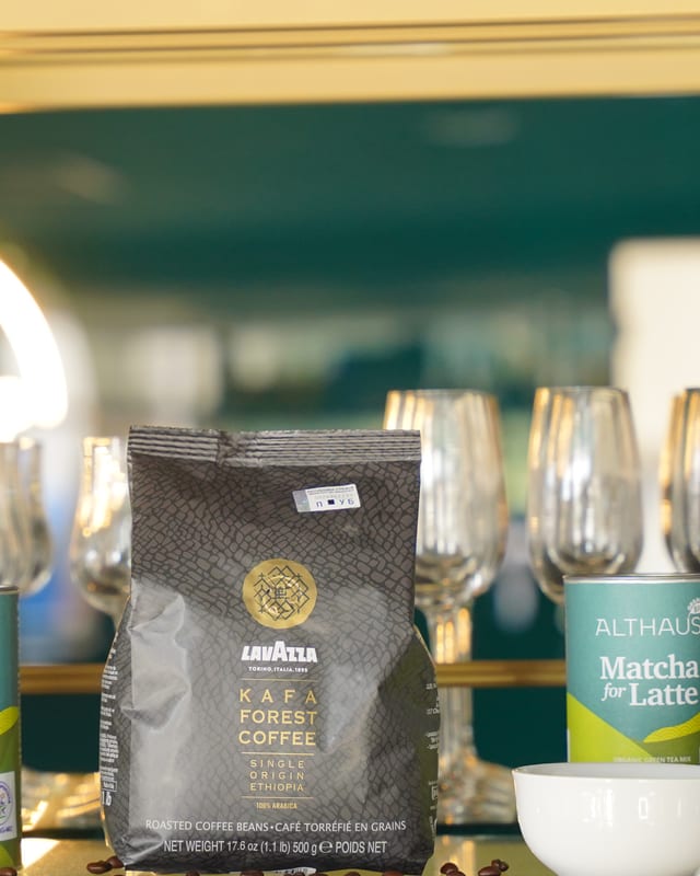Kesa Lavazza Kafa Forest Coffee kafe ispred čaša i zlatnog Hannes svetla